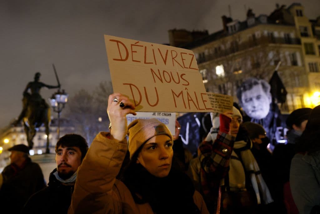 Una mujer sostiene una pancarta 
<b>que dice "líbranos del mal"</b> en la manifestaci´ón contra la violencia de género en París, Francia.