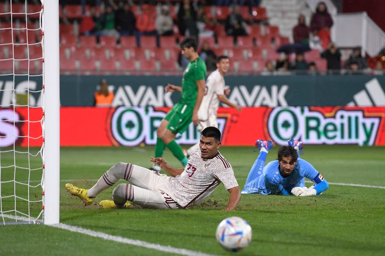 Mexico's defender Jesus Gallardo (L) eyes the ball next to Iraq's goalkeeper Jalal Hachim during the friendly international football match between Mexico and Iraq at the Montilivi stadium in Girona, on November 9, 2022. (Photo by Josep LAGO / AFP) (Photo by JOSEP LAGO/AFP via Getty Images)