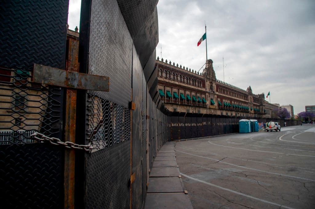 El viernes pasado, el gobierno federal y de la Ciudad de México comenzaron la instalación de 
<b>vallas de acero de casi 10 pies de altura</b> frente a edificios y monumentos para, dijeron, 
<b>intentar contener el daño que puedan sufrir los inmuebles durante la manifestación</b> que se espera tenga lugar este lunes por la tarde. Uno de los lugares que más llamó la atención fue el cerco al Palacio Nacional, en la imagen, que se encuentra en el Zócalo, en el centro de la capital.