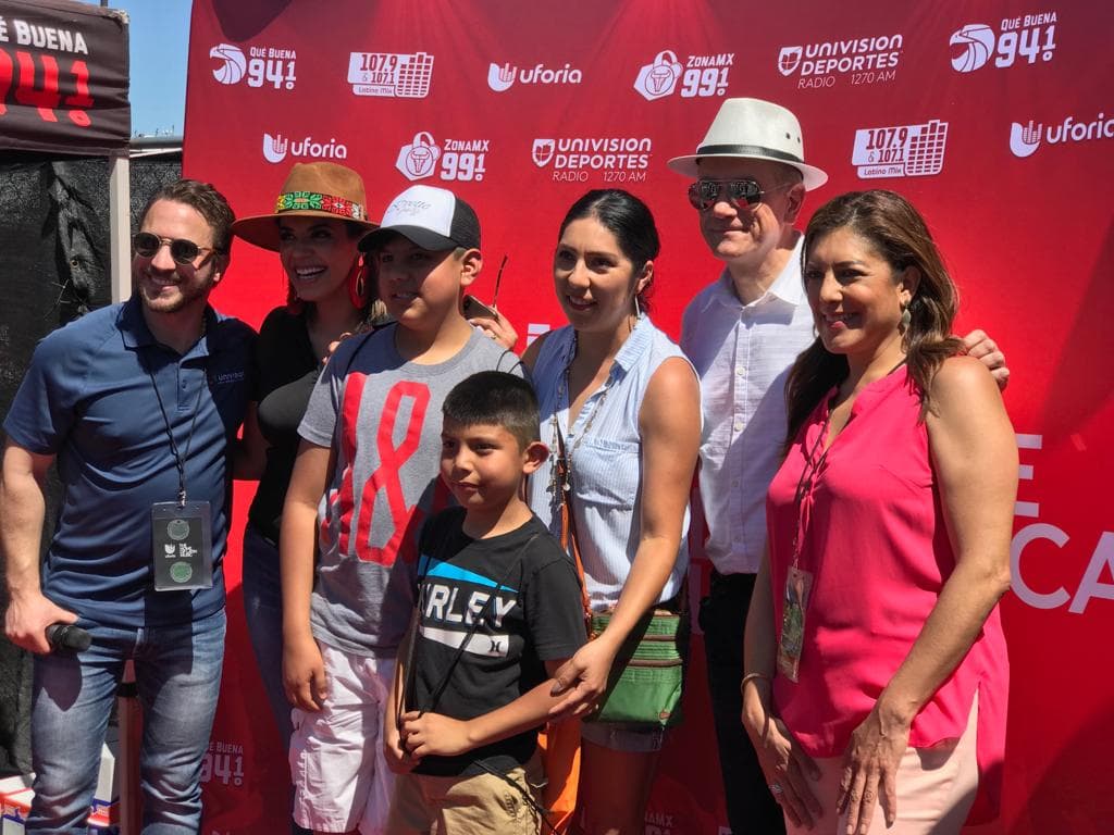 Parte del grupo de noticias de Univisión 23 DFW posa para una foto junto a varios asistentes de la actividad.