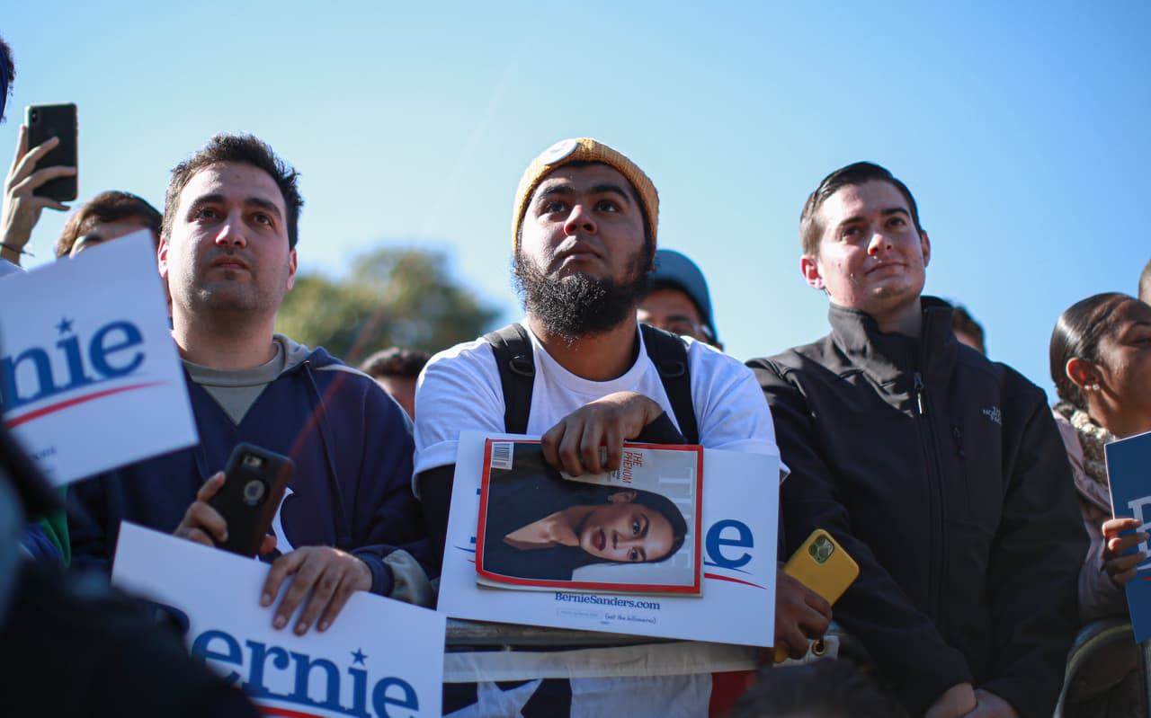 Un partidiario sostiene un ejemplar de la revista Time con Alexandria Ocasio-Cortez en la portada