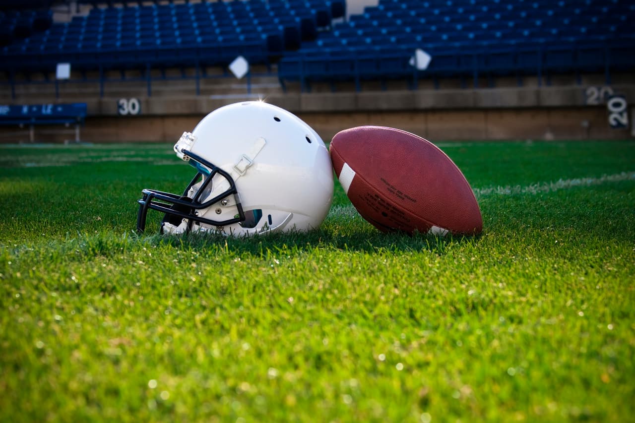 A football helmet rest on the field in a stadium