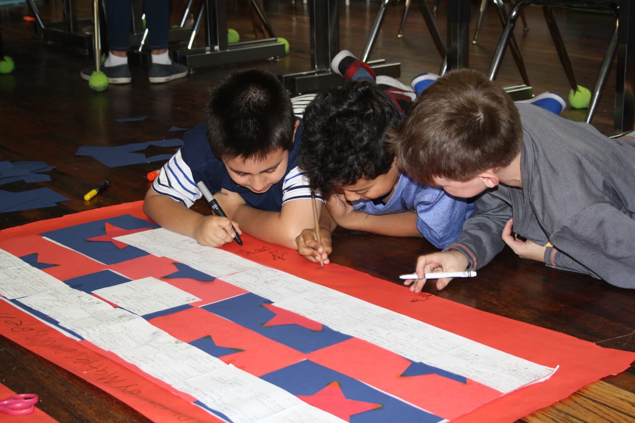 Tres estudiantes colaboran en un proyecto en la Escuela Bilingüe Oyster-Adams en la ciudad de Washington DC, donde la demanda de programas bilingües está causando preocupaciones sobre la equidad.