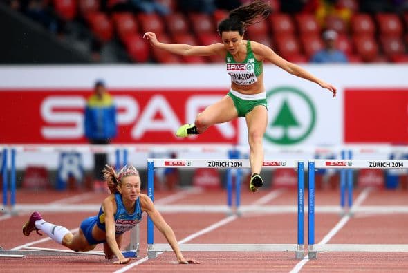 Christine McMahon de la República de Irlanda salta mientras la ucraniana Hanna Ryzhkova cae en la carrera de 400 metros con vallas en Zurich.