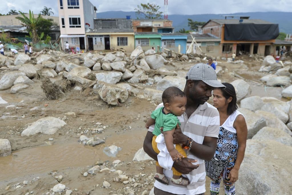 Una familia en Mocoa, Colombia revisa los daños causados por las inundaciones en su vecindario.