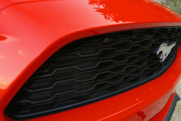 La parrilla delantera trapezoidal mantiene un diseño tipo “panal de abeja” y ubica el emblema del caballo galopando flotante