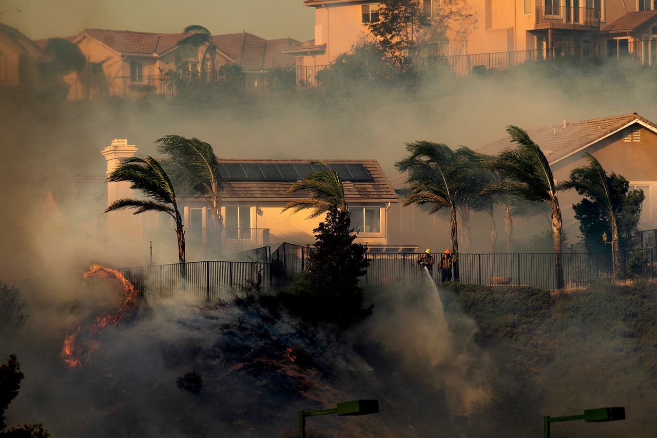 Wind whips trees as firefighters battle the Saddleridge fire in Porter Ranch, Calif., on Friday, Oct. 11, 2019. (AP Photo/Noah Berger)