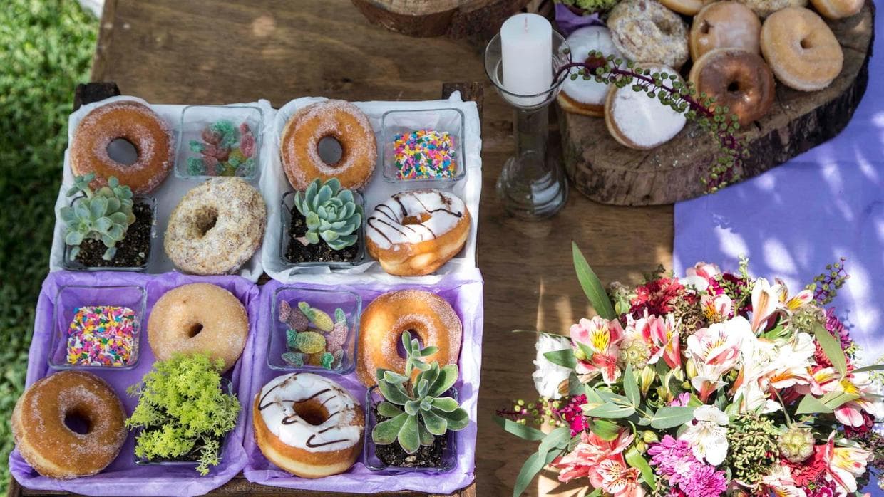 Ofrece 
<i>toppings.</i> Dale a tus invitados 
<b><a href="http://www.delish.com/cooking/g2759/insane-ways-upgrade-glazed-donut/">la opción de personalizar su propia dona</a></b>. Puedes incluir 
<i>fudge</i> de chocolate, chispas de colores, nutella, coco rallado, caramelo, o chispas de chocolate, por mencionar una buena variedad de clásicos; aunque hablando de 
<i>toppings</i> las posibilidades son tan amplias como tu imaginación.