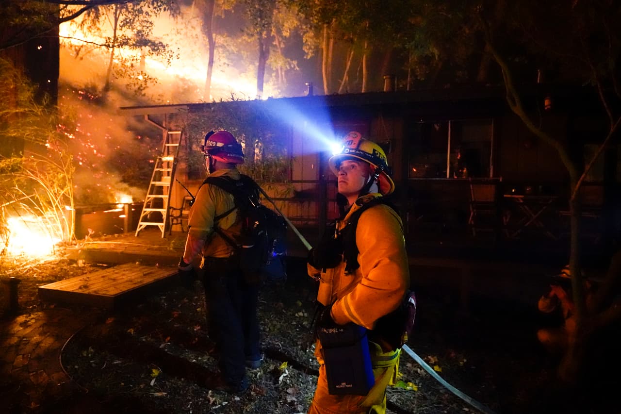 Un bombero monitorea el avance del incendio del CZU August Lightning Complex
<b>en el patio trasero de una casa</b> en Boulder Creek, California.
<br>