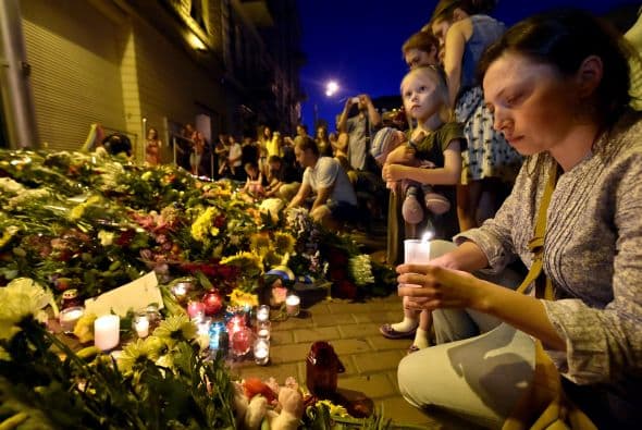 Personas dejan ramos de flores en conmemoración de las víctimas del avión estrellado de Malaysia Airlines al este de Ucrania frente de la embajada de Holanda en Kiev.