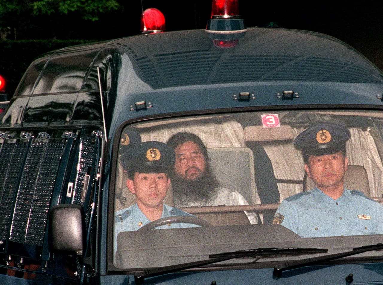 Foto de archivo del 16 de junio de 1995 del fundador del culto Aum Shinrikyo escoltado por la policía en Tokio.