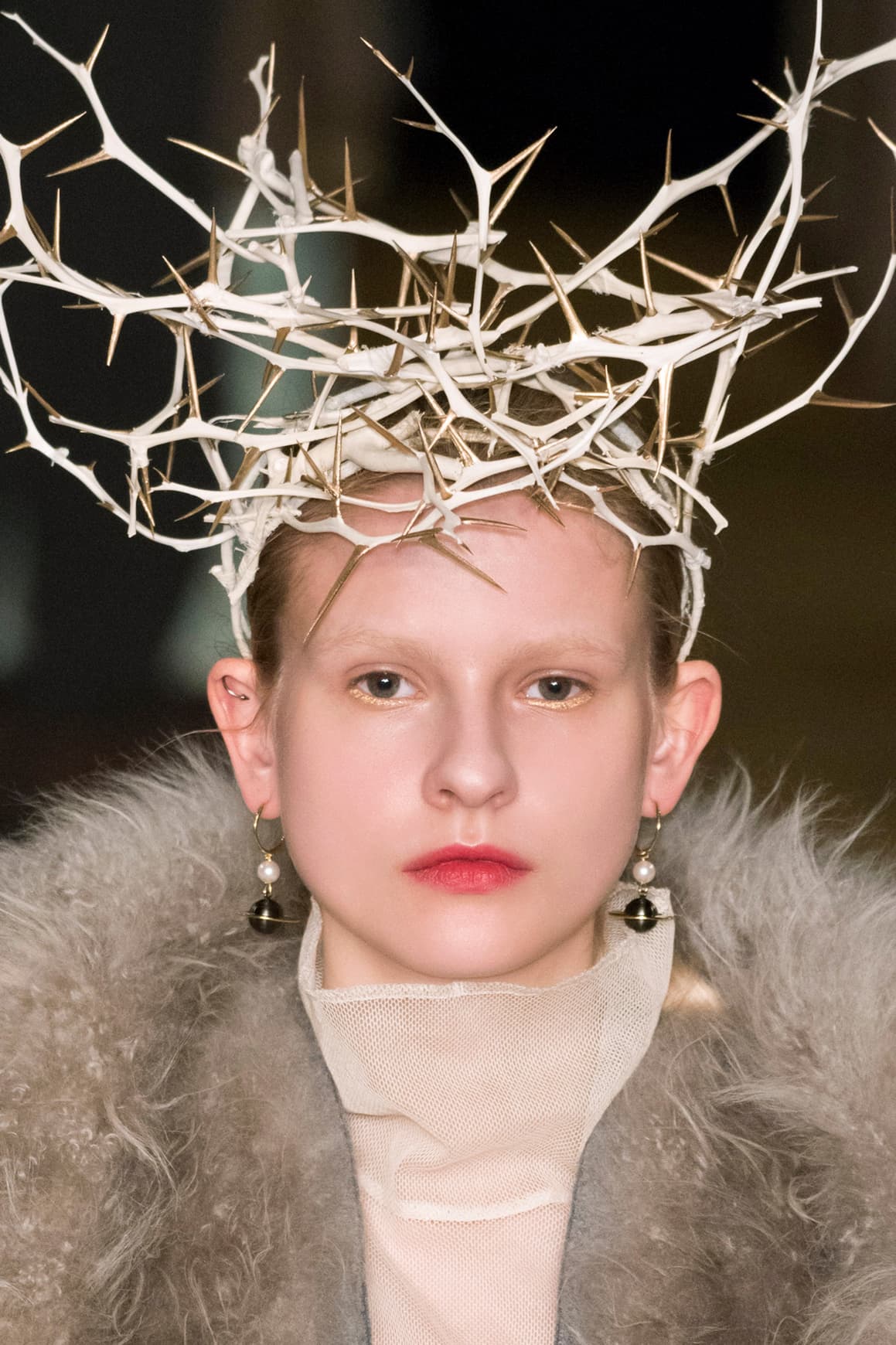 Aunque no asusta, este maquillaje sí funciona para llevarlo a una fiesta de Halloween. La ceja desaparece bajo la base de maquillaje mientras una sombra en tonos dorados invade los párpados. Para finalizar corona con un toque surrealista y decora la cabeza con un tocado de ramas como éste que propone 
<a href="http://www.vogue.com/fashion-shows/fall-2016-ready-to-wear/undercover/slideshow/collection">Undercover</a>.
<br>