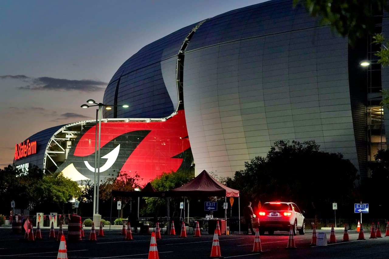 Un votante entrega su boleta el día de las elecciones afuera del State Farm Stadium temprano, el martes 3 de noviembre de 2020, en Glendale, Arizona.