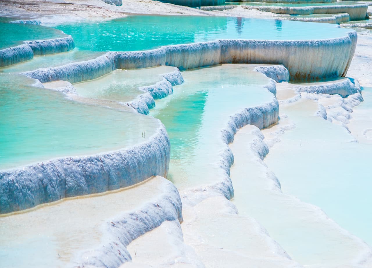 <b>Pamukkale, Turquía</b>
<br>
<br>Los seres humanos se han bañado en estas piscinas de piedra caliza formadas naturalmente desde la antigüedad, y ahora son consideradas
<a href="https://whc.unesco.org/en/list/485/"><u>Patrimonio de la Humanidad por la UNESCO</u></a>. En el "castillo de algodón” (pamukkale, en turco), el agua tibia se escurre lentamente por las terrazas blancas y su reflejo del azul del cielo ofrece un espectáculo impresionante.