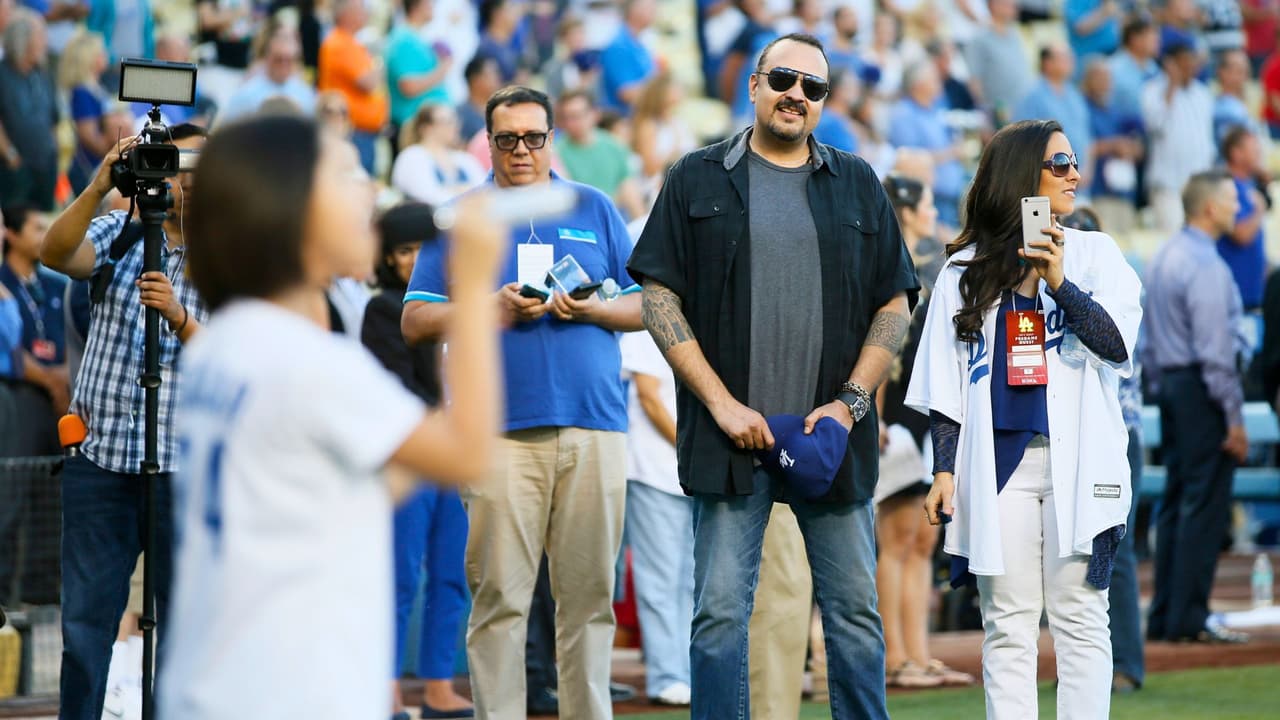 El cantante Pepe Aguilar y su esposa Aneliz Álvarez-Alcala observan cómo su hija Ángela Aguilar canta el himno nacional antes del partido de béisbol entre Los Angeles Dodgers y Washington Nationals en el Dodger Stadium.