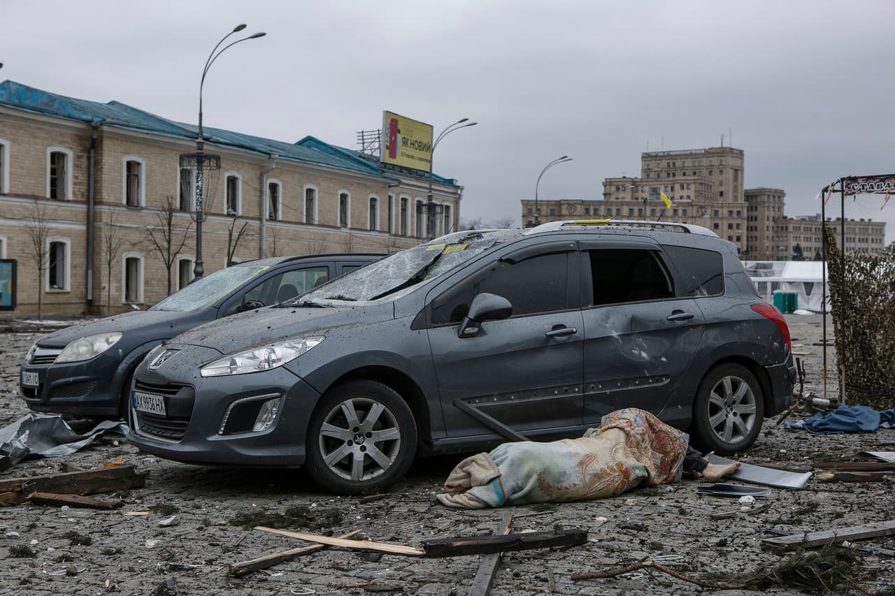 Un civil muerto junto a unos autos que fueron alcanzados por el ataque de Rusia al ayuntamiento de la ciudad de Járkov, el 1 de marzo.