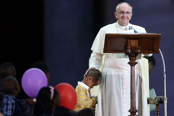 El niño se colgó de la sotana e incluso se sentó en el trono del Papa, quien le acarició la cabeza y ordenó a sus guardias no sacar al menor del escenario.