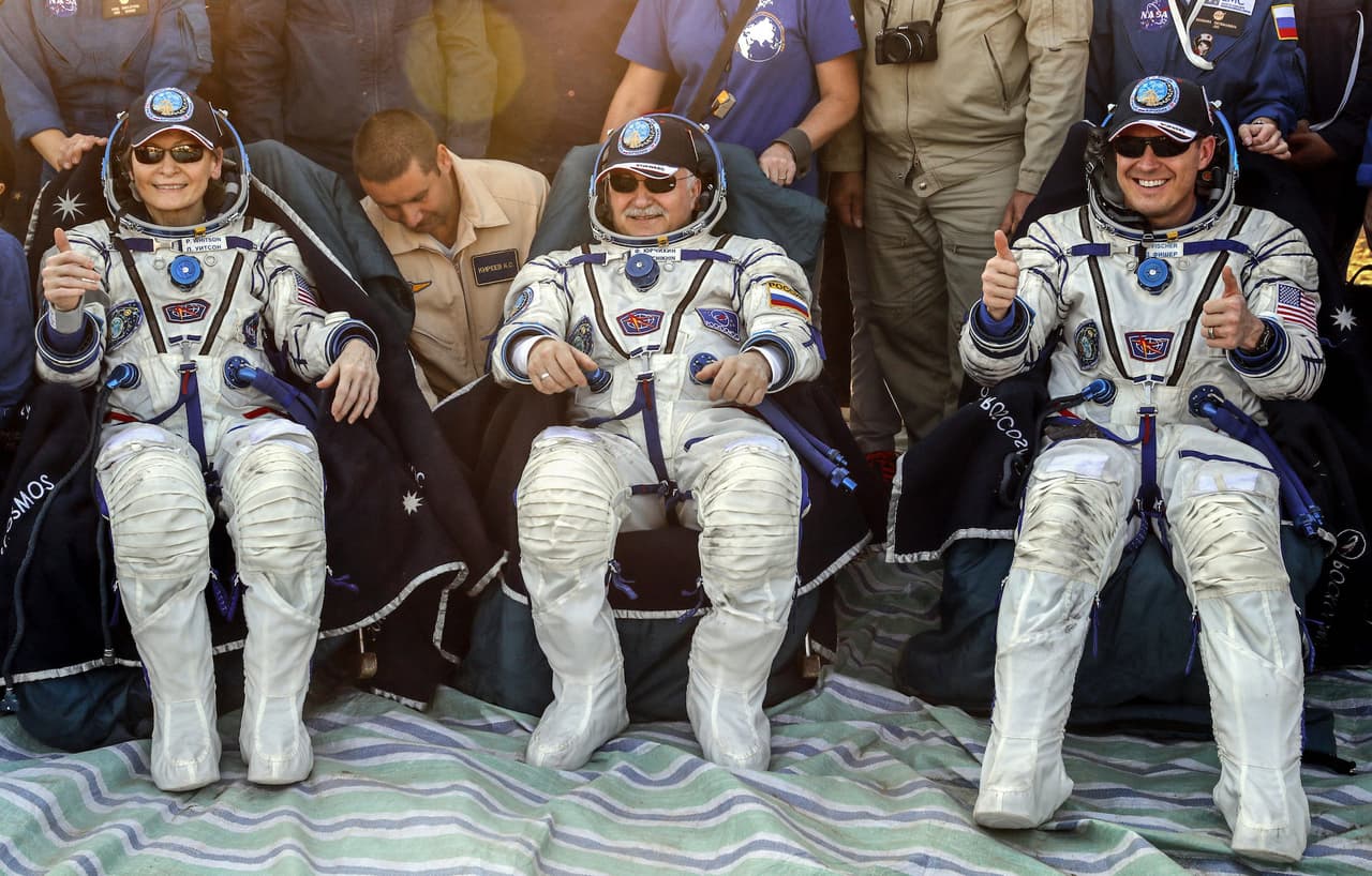 Members of the International Space Station (ISS) crew Peggy Annette Whitson of the U.S. (L), Fyodor Yurchikhin of Russia (C), and Jack Fischer of the U.S. rest shortly after the landing of the Soyuz MS-04 capsule in a remote area outside the town of Dzhezkazgan (Zhezkazgan), Kazakhstan September 3, 2017. REUTERS/Sergei Ilnitsky/Pool