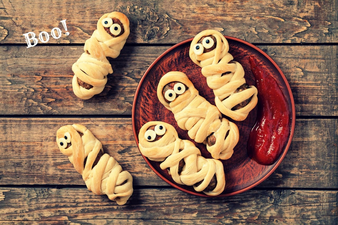 <b>Momias de salchicha</b>
<br>Para esta receta necesitas pasta de hojaldre (que puedes conseguir en cualquier supermercado). En una superficie plana estira la masa y envuelve las salchichas, dejando un espacio que será 'la cara'. Hornea a 350°F durante 15 minutos. Decora con rodajas de queso (puede ser cheddar o muenster). Para servir, puedes 'ensangrentar' las momias con ketchup o alguna
<b><a href="http://www.univision.com/estilo-de-vida/master-of-the-grill/master-of-the-grill-larga-vida-a-la-salsa-barbecue">salsa barbecue. </a></b>