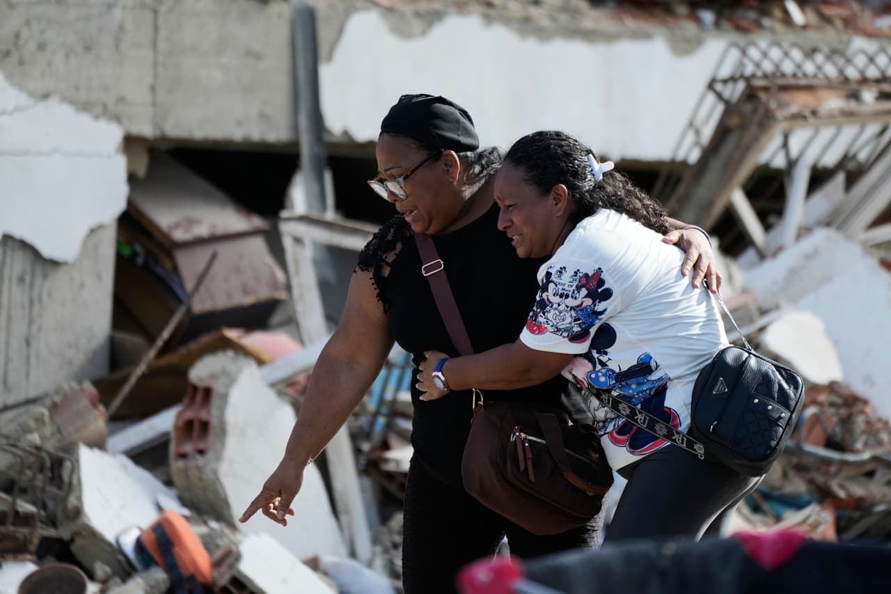 Sobrevivientes señalan un cuerpo atrapado entre los escombros dos días después de que los terremotos azotaran Catia La Mar, Venezuela, el viernes 26 de junio de 2026.