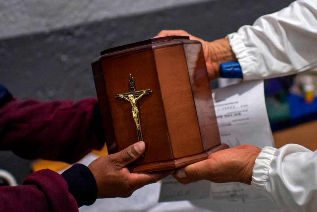 Un hombre recibe la urna que contiene las cenizas de su padre, víctima del covid-19, en el crematorio del panteón de Iztapalapa en la Ciudad de México, el 11 de junio de 2020.