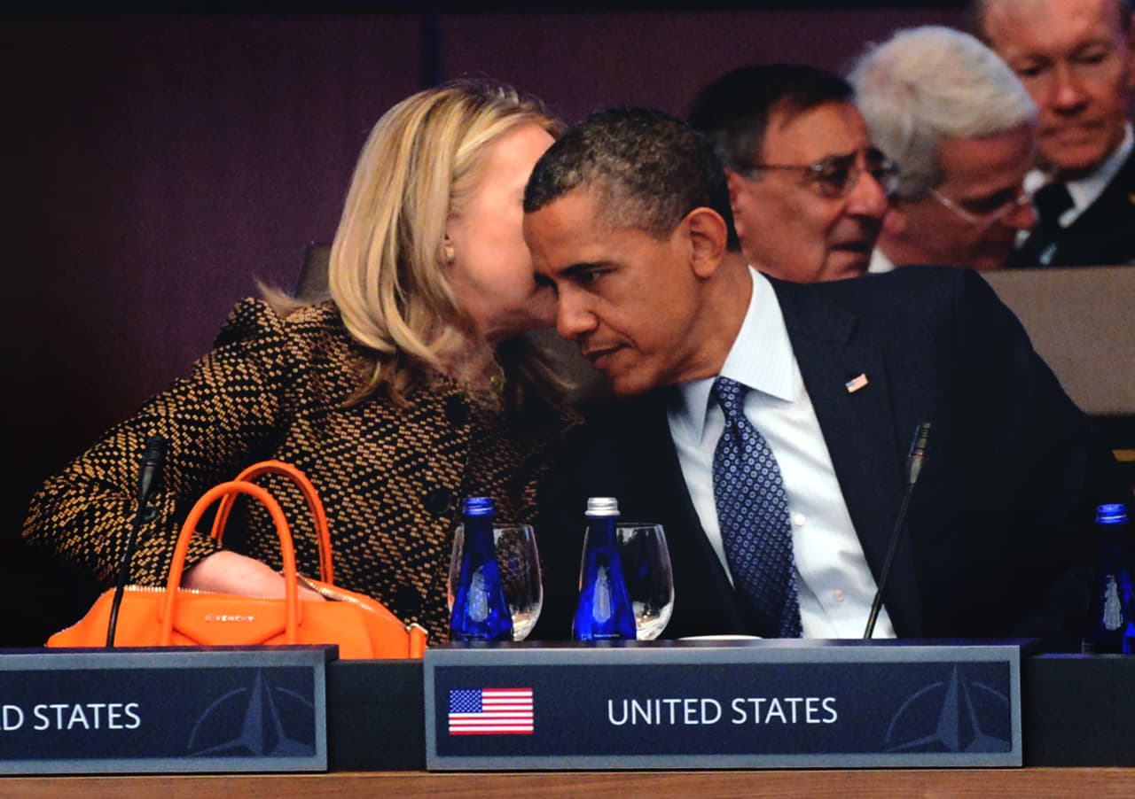 Hillary Clinton le susurra al oído al president Obama durante una cumbre de la OTAN el 20 de mayo de 2012 en Chicago, Illinois. Foto por Kevork Djansezian/Getty Images.
