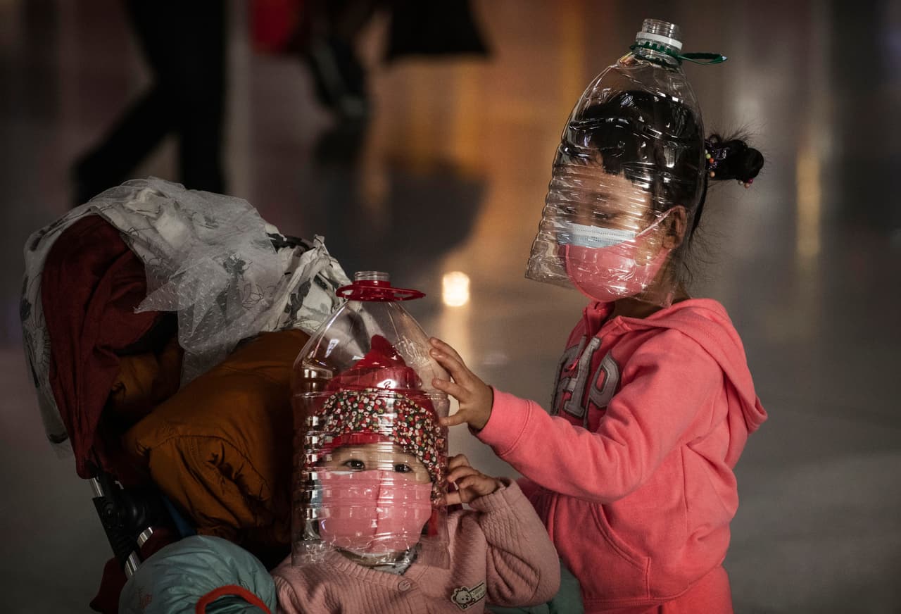<b>Un virus altamente contagioso (30 de enero). </b>Un grupo de niños llevan botellas de plástico en sus rostros en el aeropuerto de Beijing, cuando habían más 9,600 casos registrados (nada más 100 fuera de China) y más de 170 fallecidos. Ese mismo día Estados Unidos confirmó el primer contagio de coronavirus de persona a persona y la OMS declaró la enfermedad como una emergencia internacional de salud pública.
