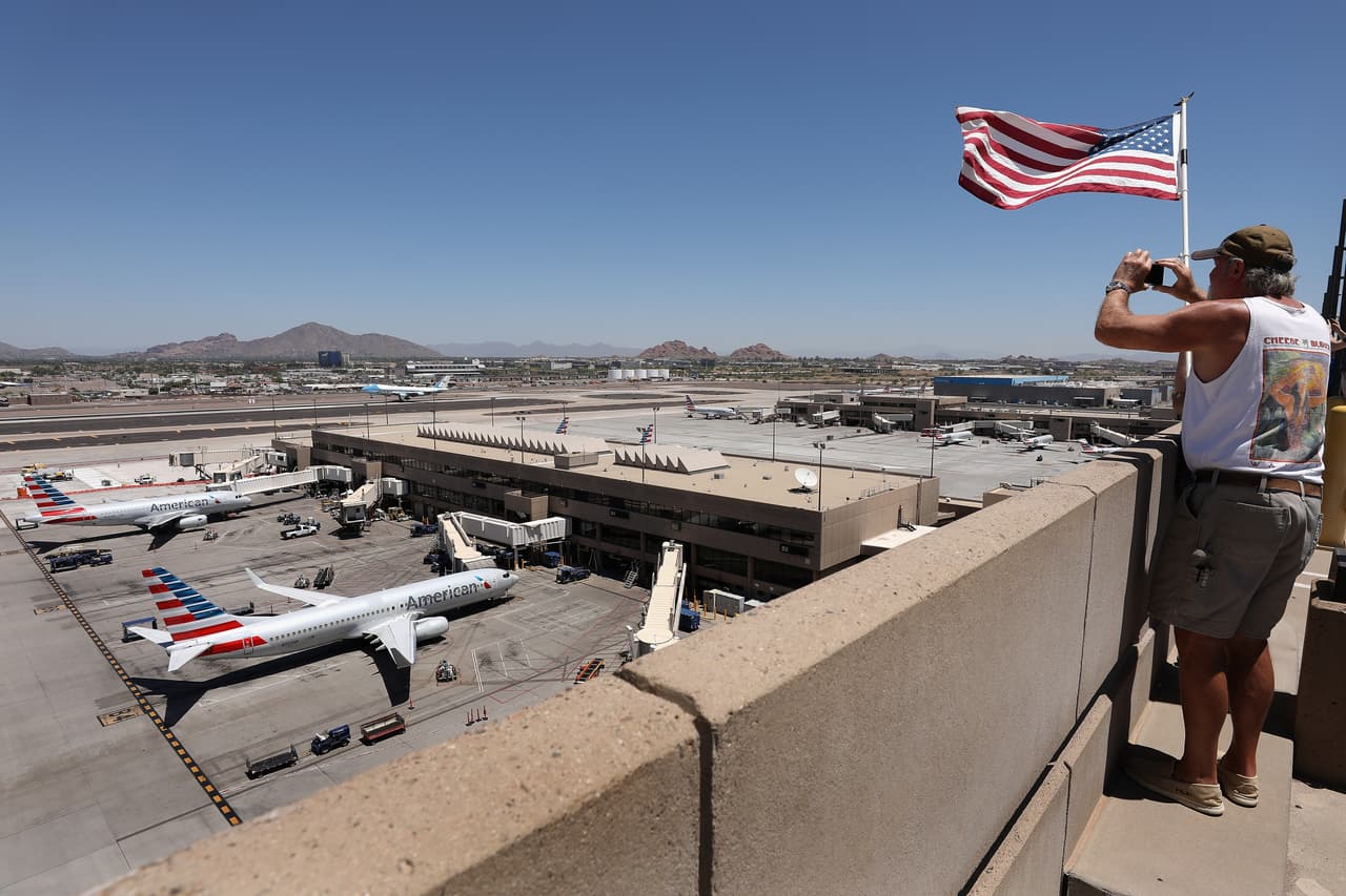 Espectadores toman fotos del aterrizaje del Air Force One en Phoenix.