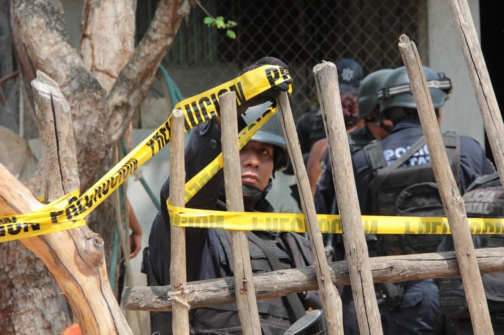 Policías estatales vigilan una vivienda donde se registró un ataque, en donde siete integrantes de una misma familia, incluyendo tres mujeres y dos bebés, murieron en el poblado de San Pedro Cacahuatepec, ubicado en la zona rural del municipio de Acapulco del sureño estado mexicano de Guerrero.