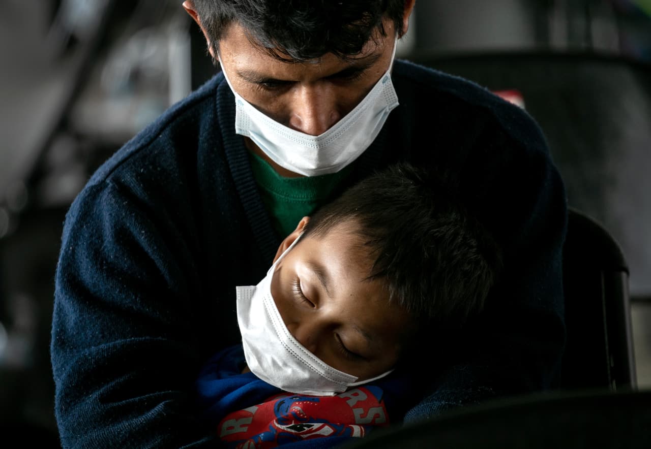 <b>Vigila su sueño.</b>Un padre guatemalteco sostiene a su hijo dormido, de 4 años, después de que funcionarios de inmigración de Estados Unidos los liberaran el 25 de febrero de 2021 en Brownsville, Texas. Después de cruzar la frontera desde México, fueron procesados por las autoridades de inmigración de EE. UU. Y luego llevados a una estación de autobuses para continuar su viaje a destinos alrededor de los EEUU mientras esperaban sus audiencias de asilo.