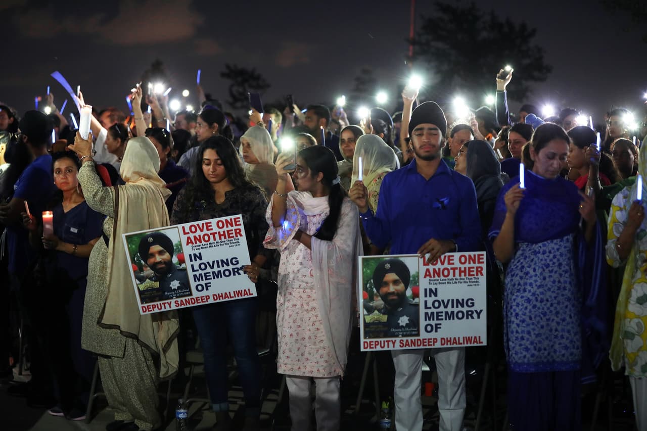 "Ámense unos a otros", se lee en el mensaje de las pancartas de las personas que asistieron a la vigilia del oficial caído.