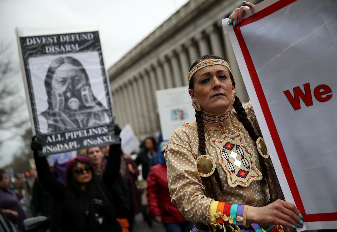 Los manifestantes llevaron letreros mientras marchaban durante una manifestación contra el oleoducto Dakota Access.