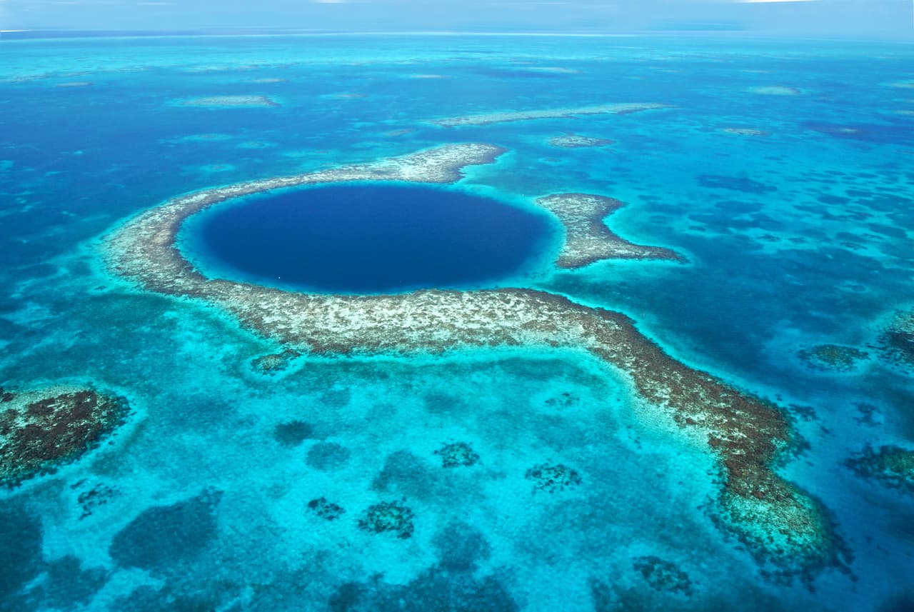 <b>El Gran Agujero Azul, Belize</b>
<br>
<br>A unas 60 millas de la costa de Belice, el arrecife Lighthouse tiene hermosos corales y aguas turquesas poco profundas. El Gran Agujero Azul, un sumidero perfectamente circular de 1,000 pies de ancho se hizo famoso en 1971 gracias al explorador Jacques Cousteau. Entonces el francés dijo que este es uno de los mejores sitios para bucear del planeta.
<br>