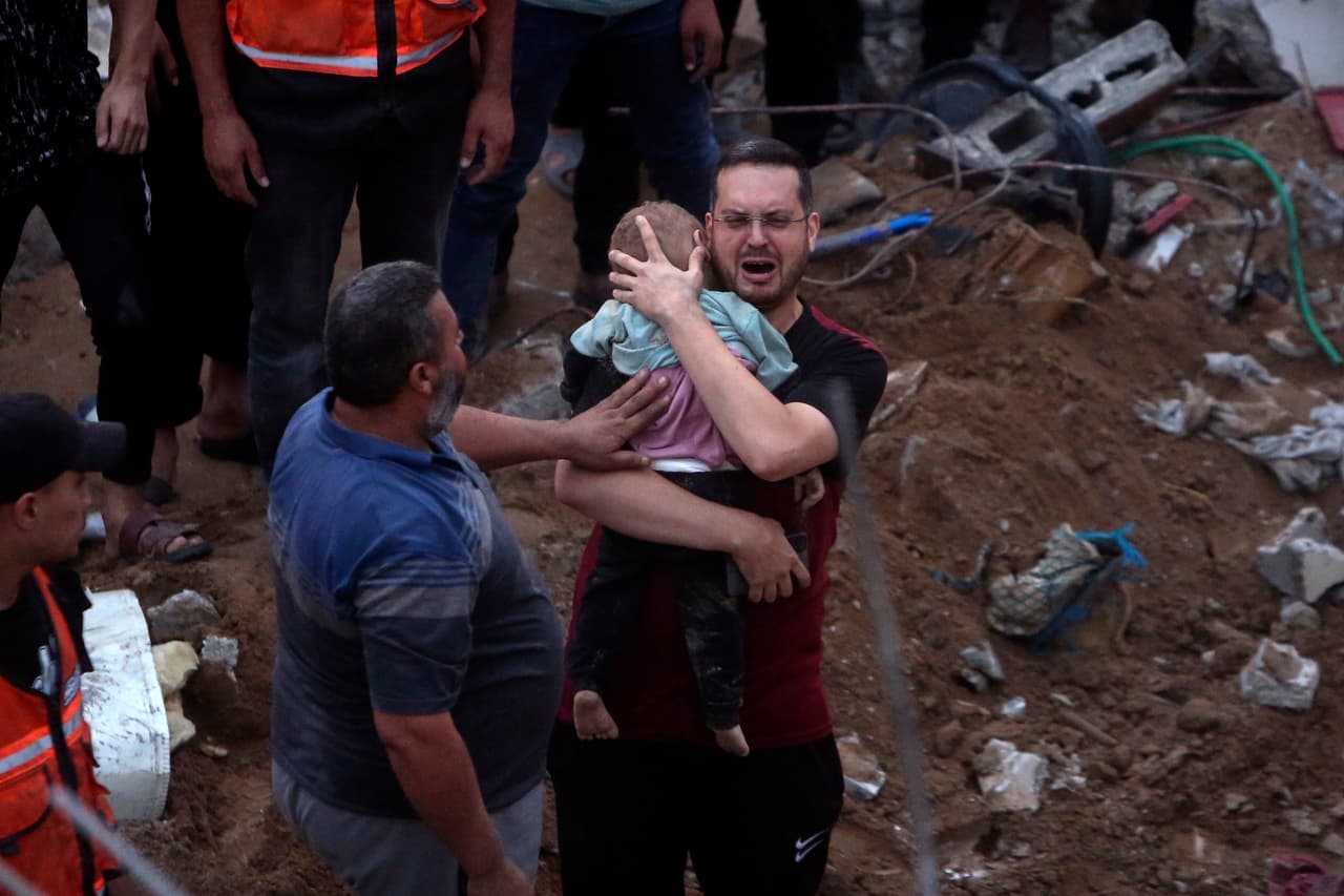 Un hombre palestino llora mientras sostiene a un niño muerto que fue encontrado bajo los escombros de un edificio destruido por ataques israelíes en el campo de refugiados de Nusseirat, en Gaza.