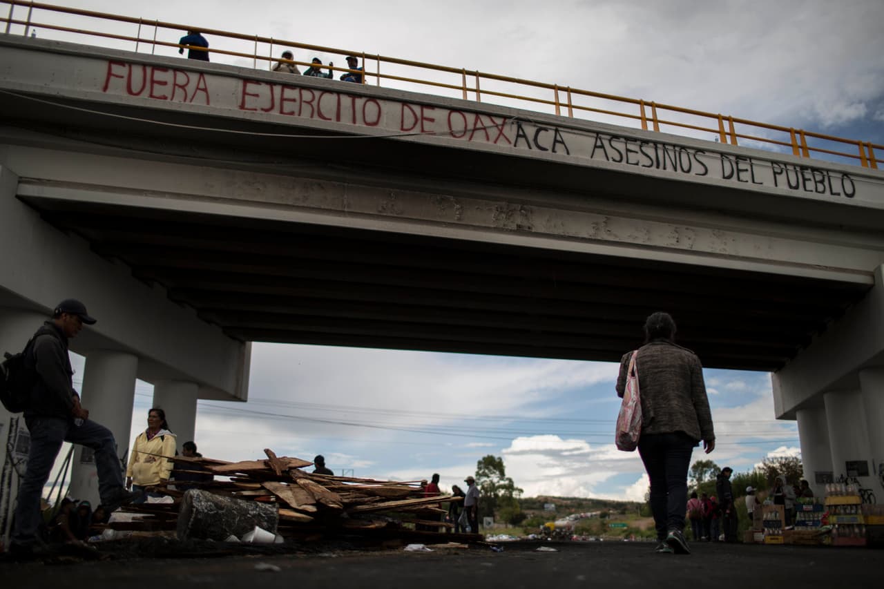 El gobernador de Oaxaca, Gabino Cué, atribuyó los choques violentos a grupos infiltrados afines al magisterio. Al día siguiente de los disturbios varias personas caminan normalmente sobre los restos del encuentro.