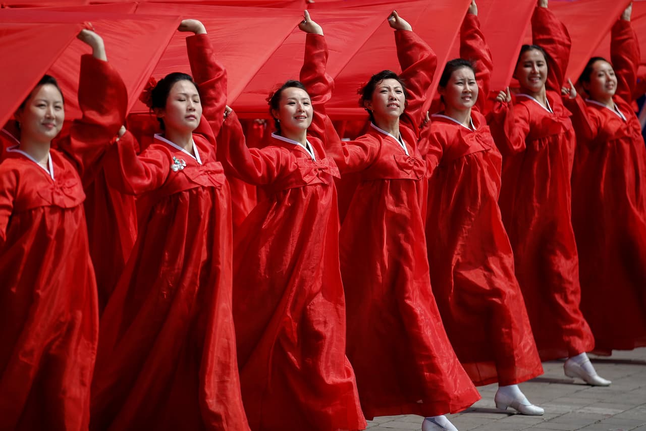 Mujeres vestidas con un atuendo de rojo, que es el color de la bandera que portan.