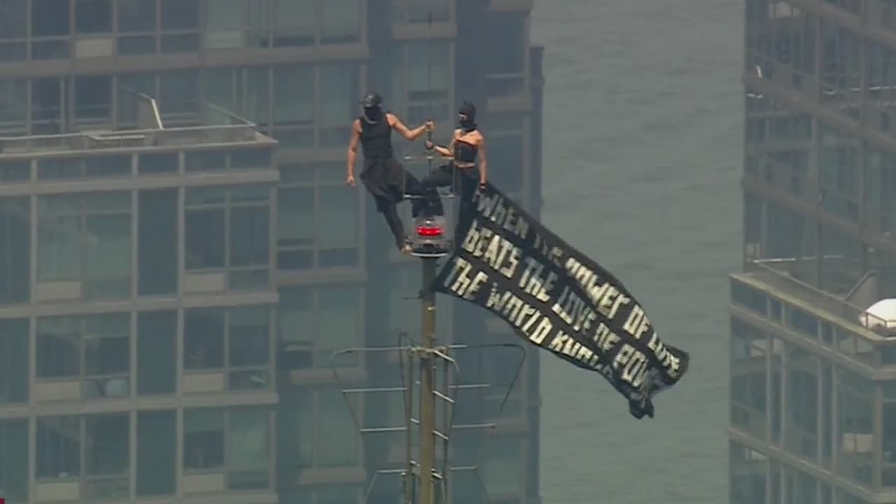 Dos personas escalan el Empire State Building y despliegan pancarta de protesta por la paz.