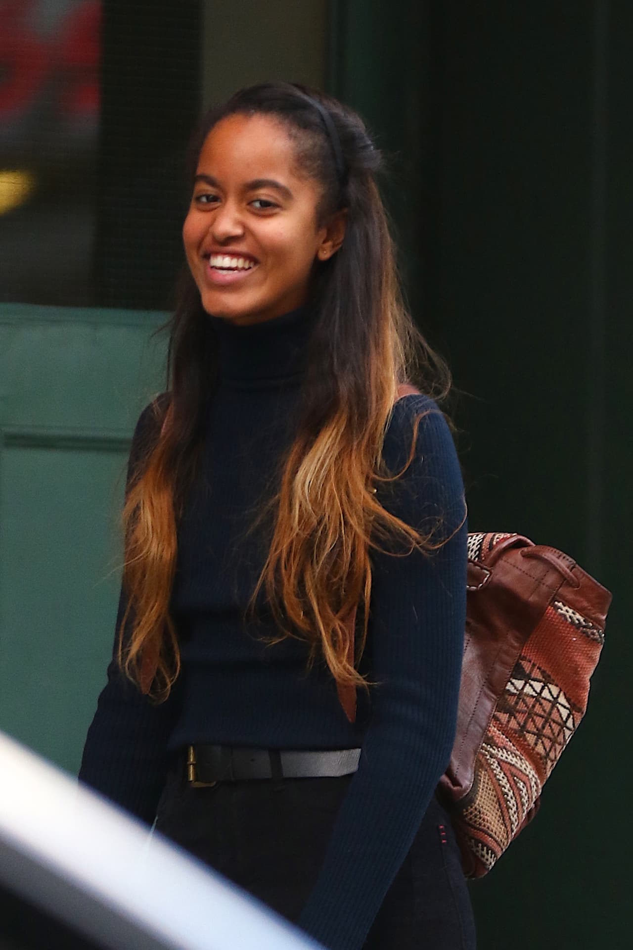 Malia Obama usa tenis Convers Chuck Taylor, jeans negros tipo skinny y saco cuello de tortuga.
