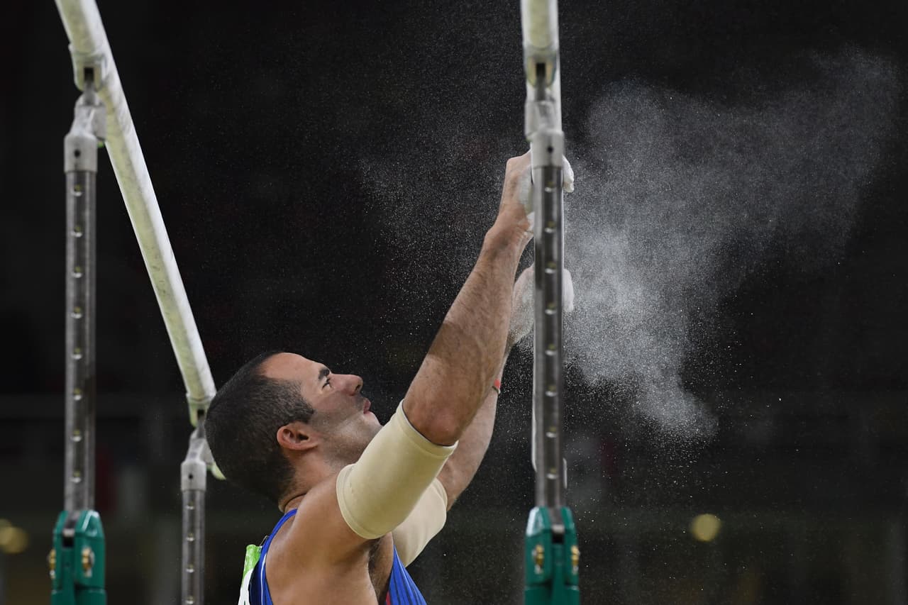 El gimnasta completa un evento en la final de las barras paralelas.