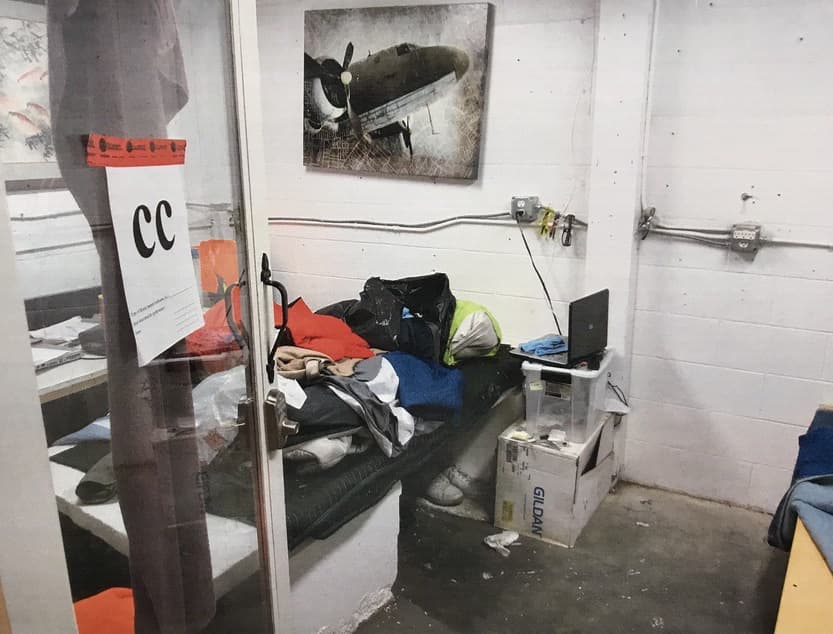 Una computadora portátil sobre una caja de cartón y un recipiente de plástico quedó en un espacio de la bodega. Un cuadro de un avión antiguo parecía aligerar la dura realidad del huésped.