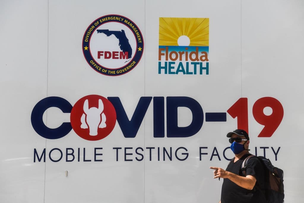 Un hombre pasa frente a un centro móvil de pruebas de covid-19 en Miami Beach.