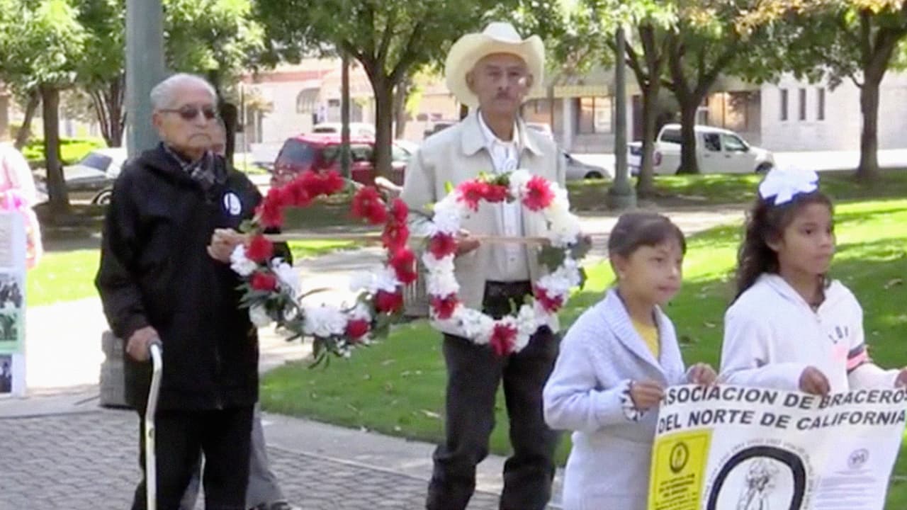 Los exbraceros colocan una ofrenda floral acompañados por sus nietos y bisnietos.