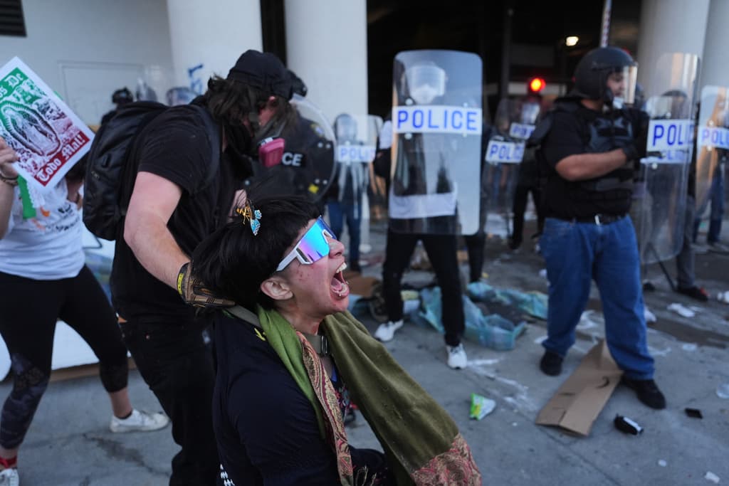 Un manifestante reacciona tras ser atacado con gases lacrimógenos por la policía federal en el Centro de Detención Metropolitano del centro de Los Ángeles.