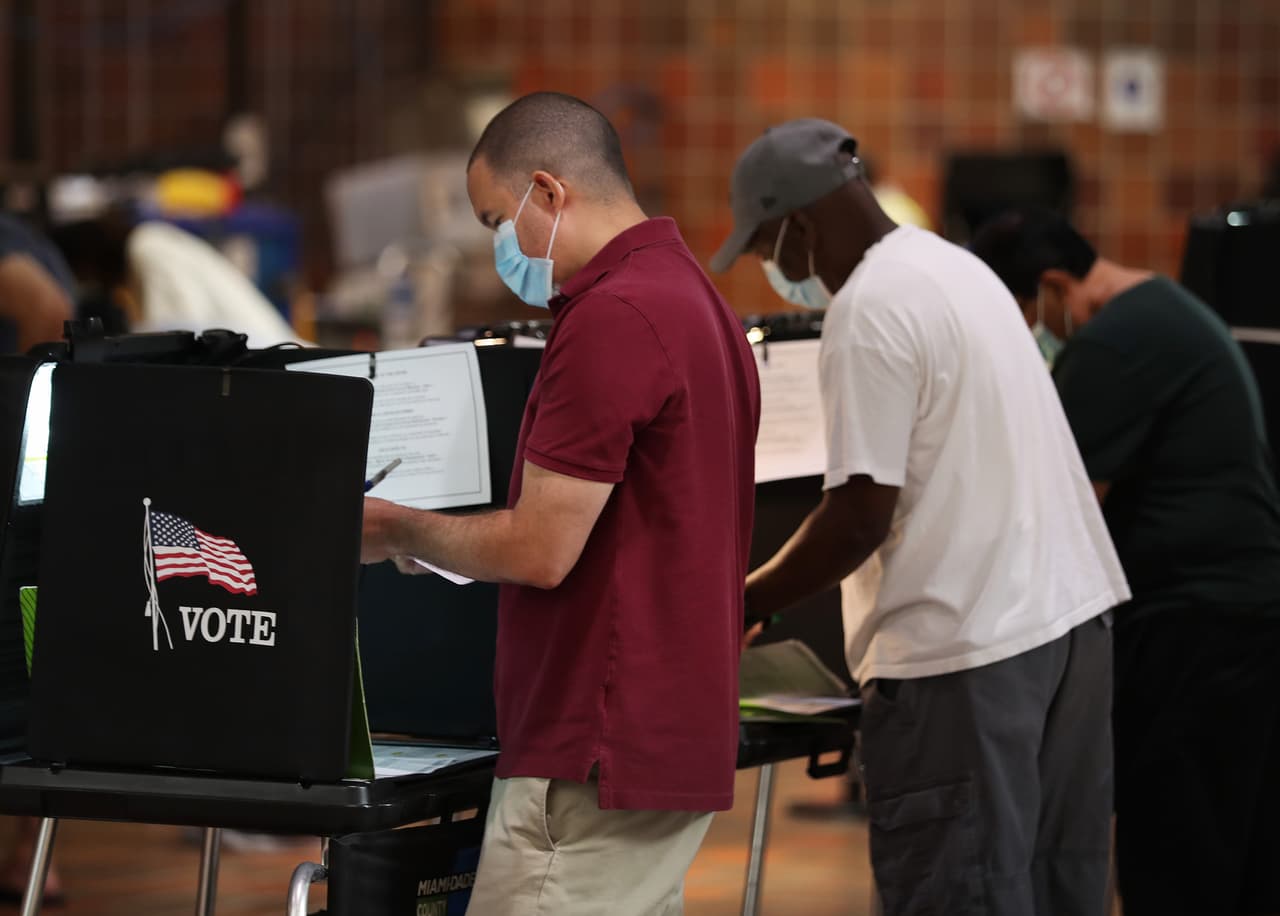 Votantes jóvenes y mayores en un centro de votación en Miami. La cifra de sufragios enviados por correo en Florida se está aproximando a los 2.7 millones realizados en el 2016 cuando los republicanos gozaban de una ventaja de 70.000 votos. Trump ese año derrotó a Hillary Clinton en Florida por 113,000 votos. 
<br>