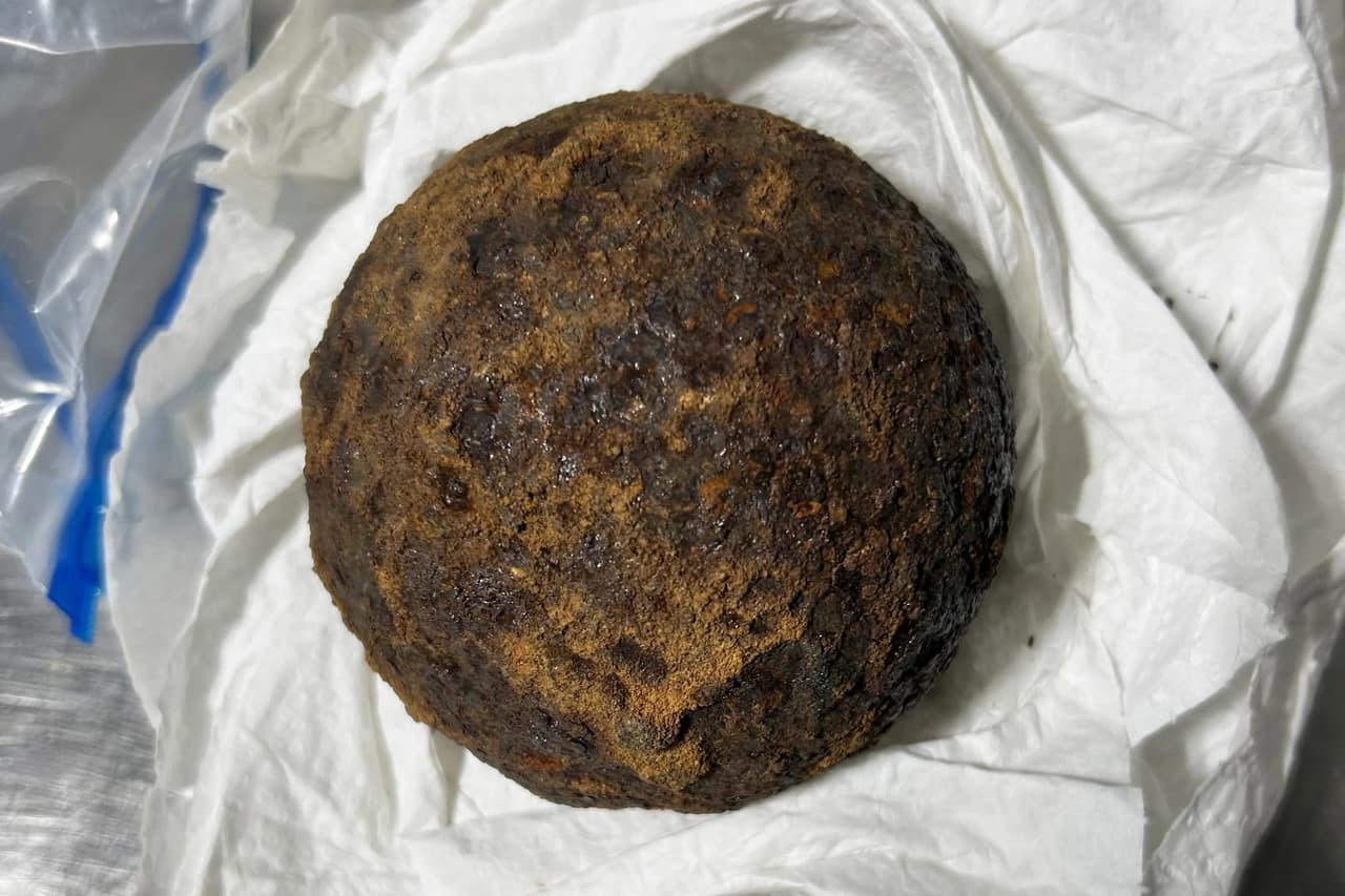 :Una vieja bala de cañón de hierro oxidado y de forma esférica, descubierta e incautada por los agentes de seguridad durante una revisión de equipaje en el aeropuerto.