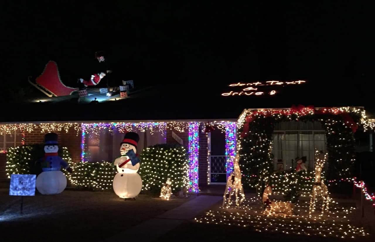 Un Papa Noel accidentado en el techo y el letrero don't text and drive decoran la vivienda.