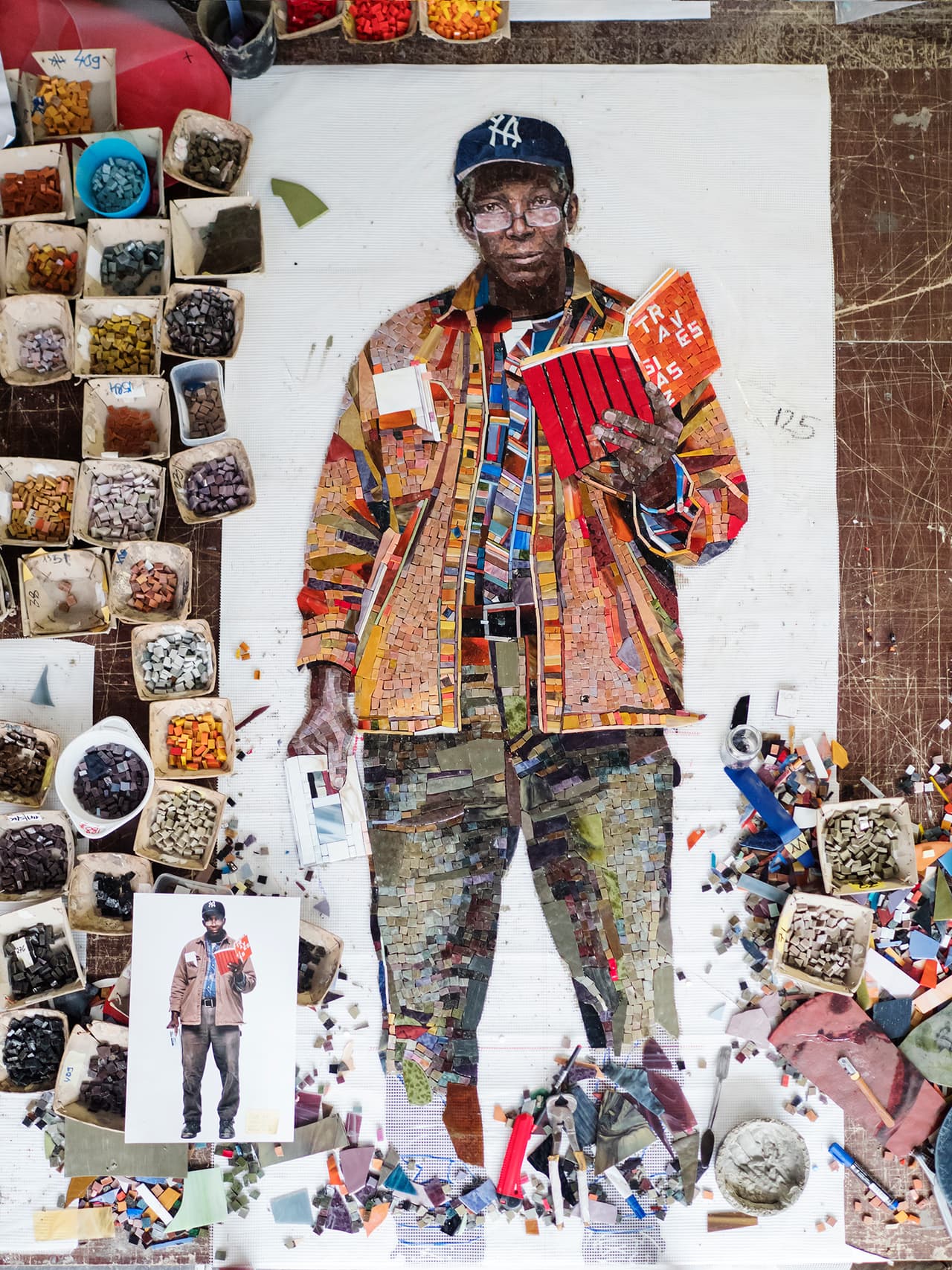 “Perfect Strangers”, de Vik Muniz, basada en fotos reales, rinde tributo a todas las personas con que uno podría toparse en el metro de Nueva York, incluyendo un aturdido hombre de negocios, chicos de la escuela con rostros aburridos y un felino peludo.