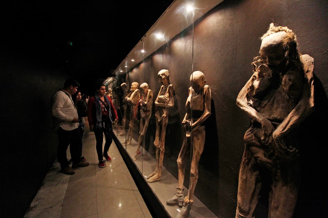 Visitantes observan la exposición de cuerpos del Museo de las Momias de Guanajuato, a unas 100 millas al noreste de la Ciudad de México. El lugar alberga unos 117 cuerpos secos bien conservados. "Hay 64 mujeres, 30 hombres, 16 infantes, 3 fetos, 3 cabezas y un busto”, según explicó a la agencia EFE Ricardo Rodríguez Ojeda, director del museo.