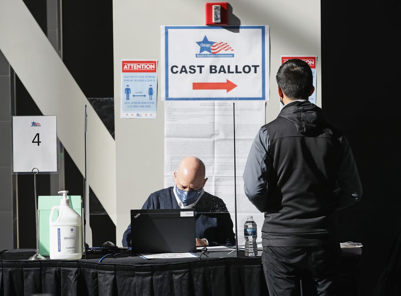 Un trabajador electoral verifica el registro de un votante en el United Center, donde se instalaron 70 máquinas de votación.
