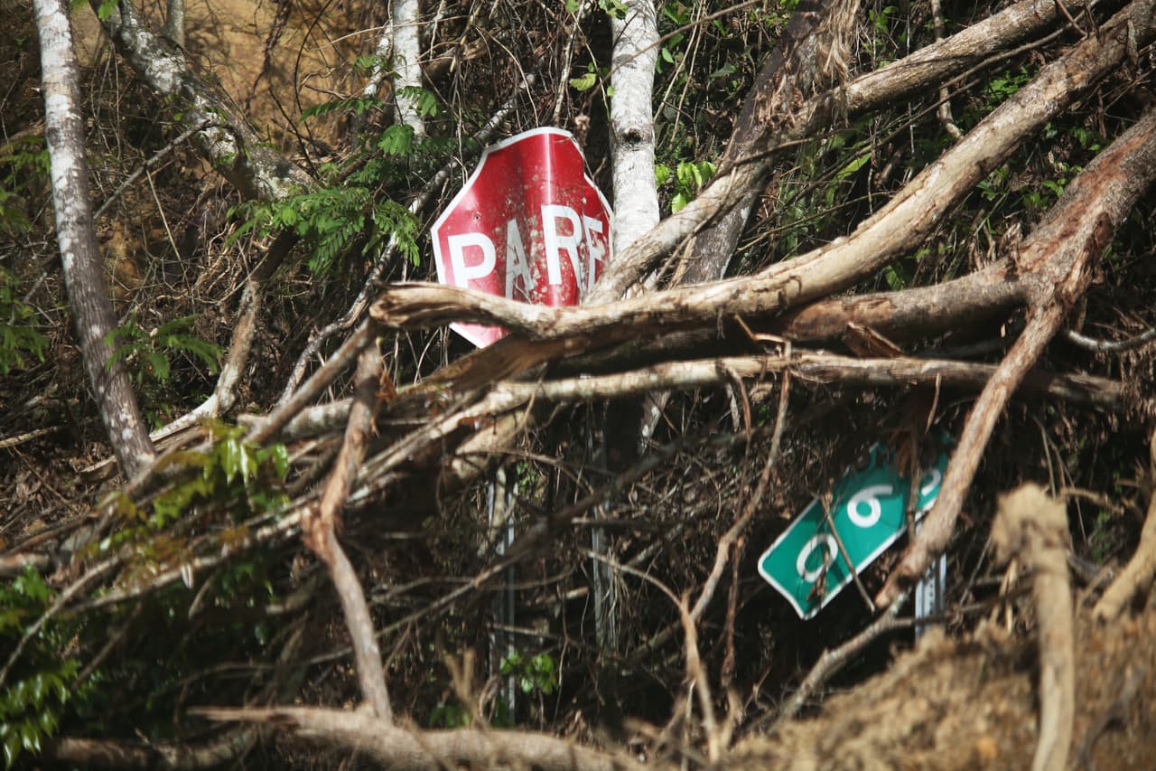 Señales de tránsito apiñadas por la fuerza del agua desbordada del río Viví, en Utuado.